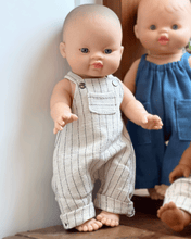 Two dolls, one in a striped outfit and the other in a blue dress, standing against a neutral background.